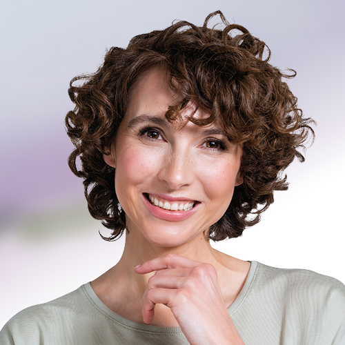 Frau mit Locken lächelt.