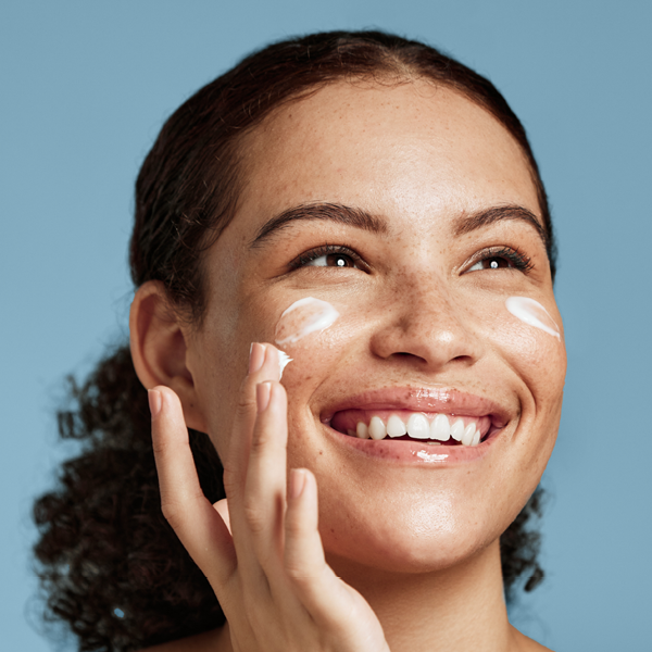 Frau, die sich das Gesicht eincremt