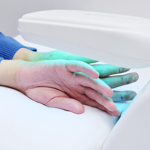 Zwei Hände unter einer UV-Lampe.