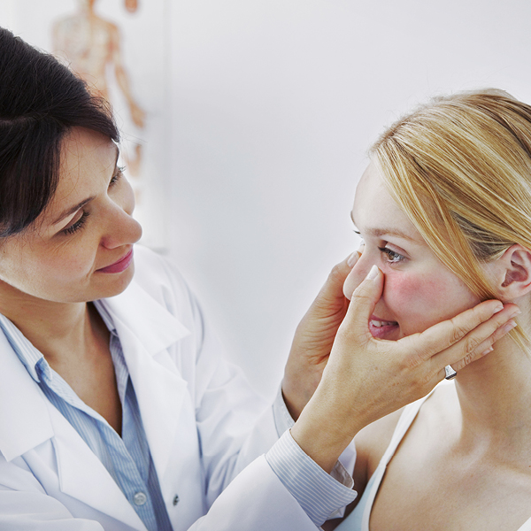 Frau mit Rosacea, die sich in Behandlung bei einer Ärztin befindet
