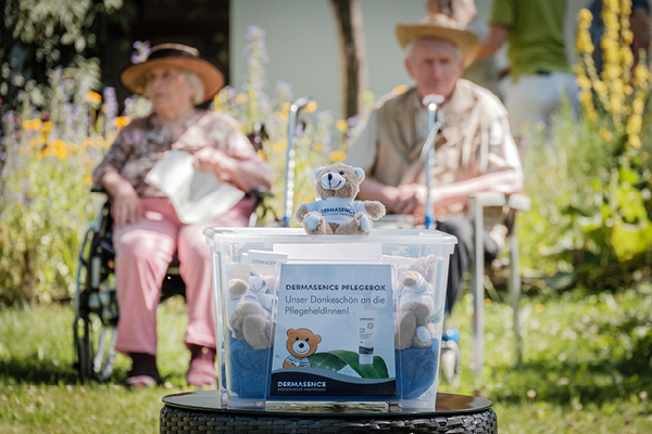 DERMASENCE Produktspende, im Hintergrund Senior*innen bei den Corona Hofkonzerten