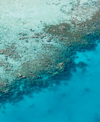 Luftaufnahme eines Gewässers mit Riff