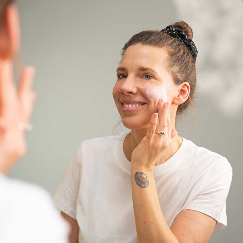 Frau trägt DERMASENCE Solvinea Sonnenschutz-Gelcreme LSF 50+ auf