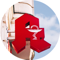 Rotes Apothekenschild an einer Hausfassade