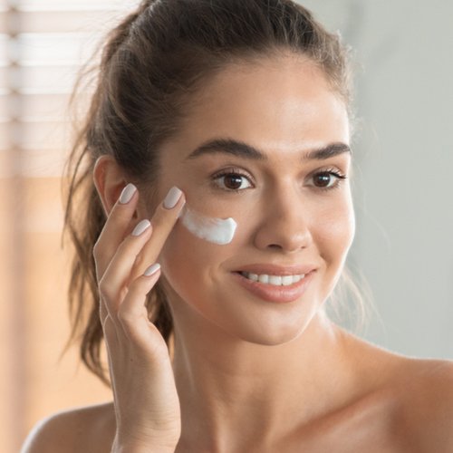 Junge Frau mit Creme im Gesicht