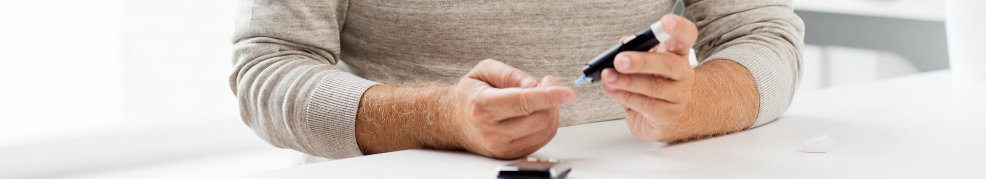 Diabetes als Grund für Hautveränderungen Mann benutzt Glykosemessgerät