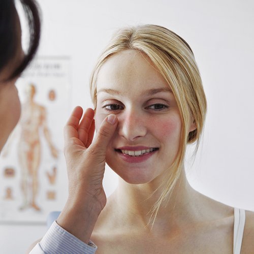 Frau mit Rosacea, die von einer Ärztin behandelt wird