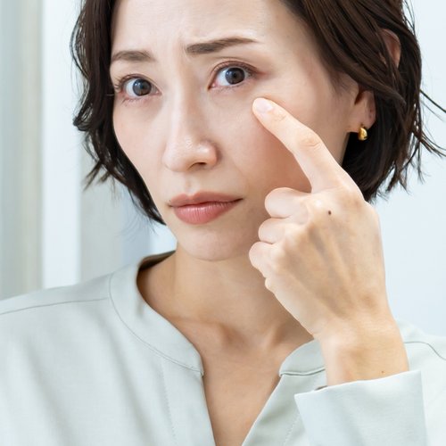 Frau, die sich mit ihrem Finger auf das Auge zeigt