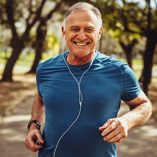 Ein älterer lachender Mann beim Joggen.
