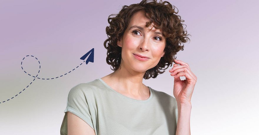 Brünette Frau mittleren Alters mit Locken und Papierflieger-Icon