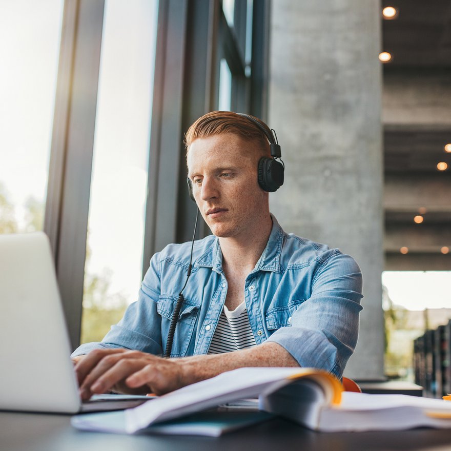 Junger Mann arbeitet am Laptop