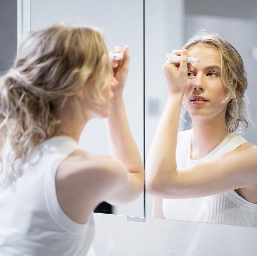 Junge Frau trägt Anti-Pickel-Roller auf